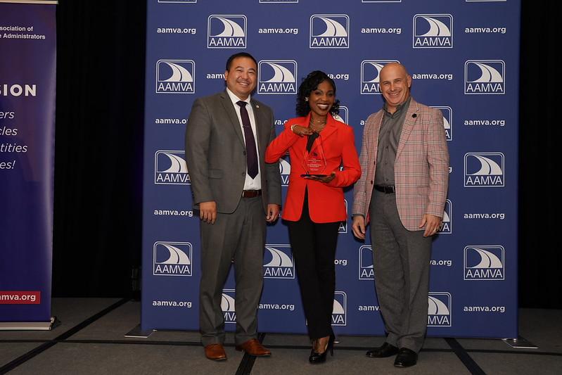 DVS Director Pong Xiong (left) and DVS Driver Services Program Director Jody-Kay Peterson (center) accept the AAMVA Community Service Award for the DVS reintegration license program. Also pictured: AAMVA President Ian Grossman.