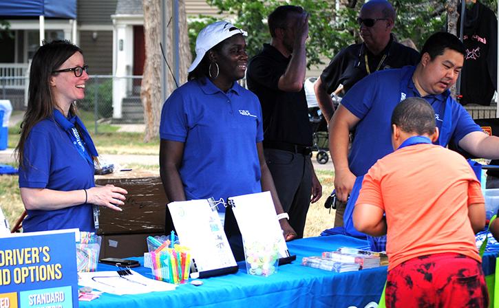 Three DPS staff members stand behind an event table