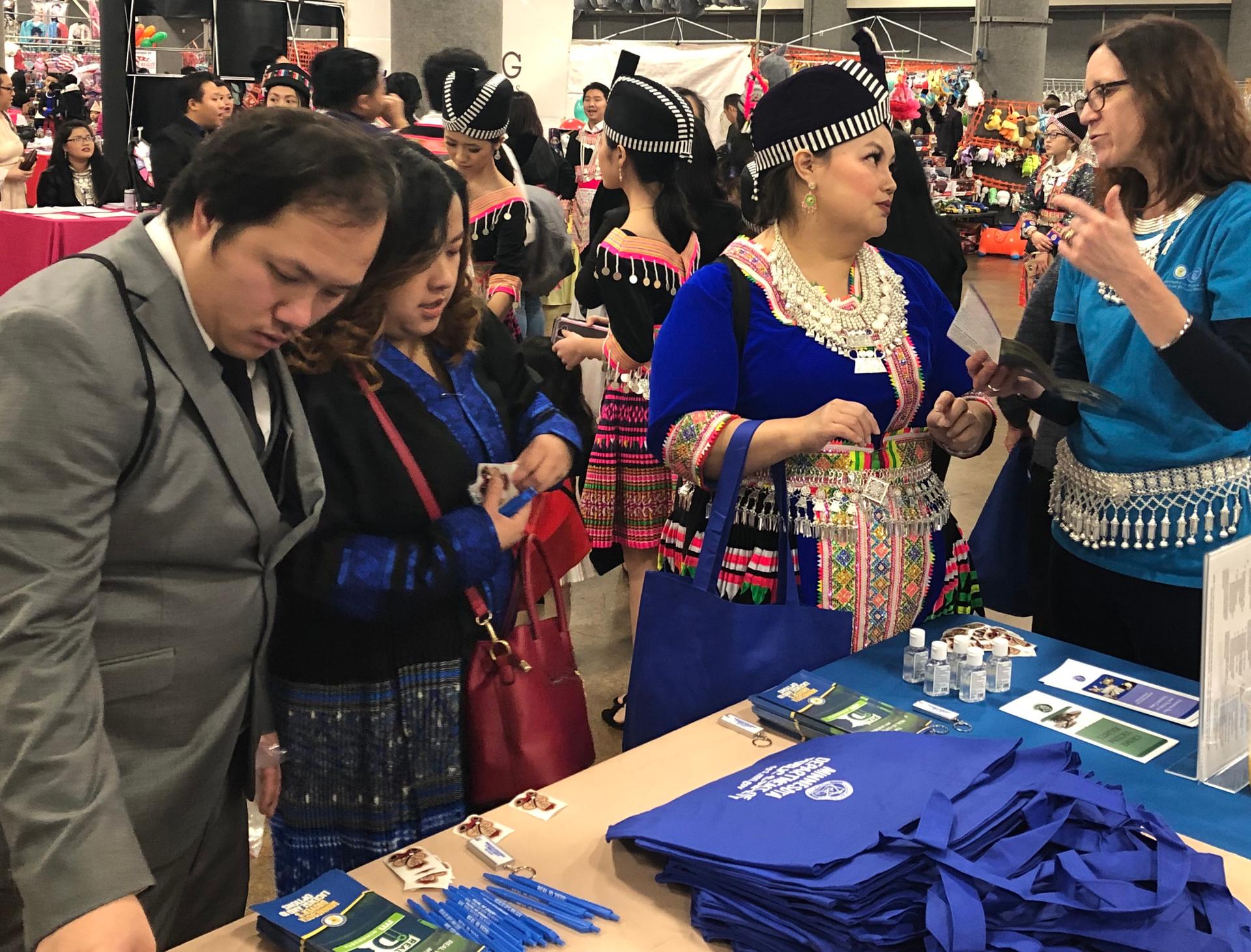 A staff member chats with people attending Hmong New Year.